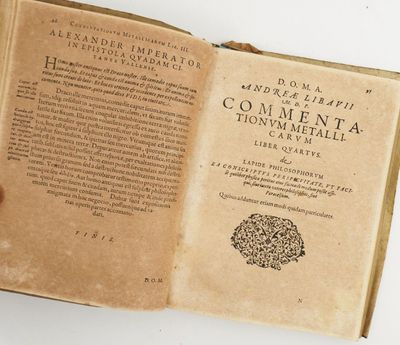 quelqu'un tient un livre ouvert sur une surface blanche
