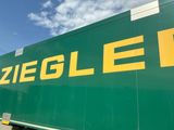 un grand camion vert avec des lettres jaunes sur le côté