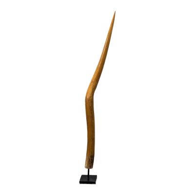 une photo d'une sculpture en bois représentant un objet incurvé posé sur un socle noir