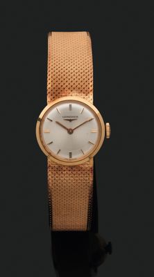 gros plan d'une montre-bracelet en or sur une surface noire