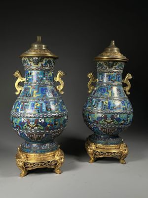 pair of blue and gold vases with handles on stands