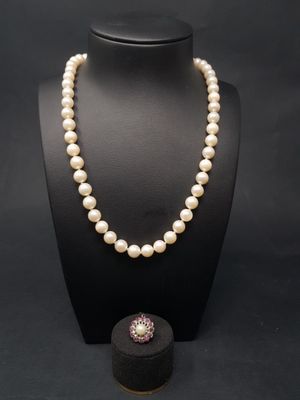 un collier de perles blanches et une boîte noire sur fond noir