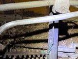 une tronçonneuse posée par terre à côté d'un tuyau