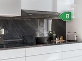 a black and white kitchen with a green sign on the wall