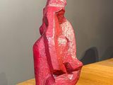 a pink sculpture sitting on top of a wooden table