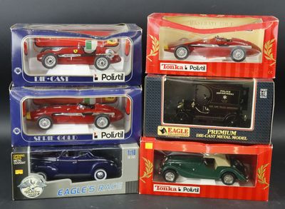 three boxed boxed toy cars in boxes on a black surface