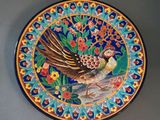 a decorative plate with a bird and flowers on it