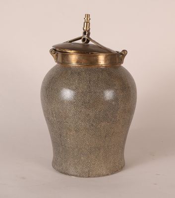 une image représentant un vase gris avec un couvercle doré sur fond blanc