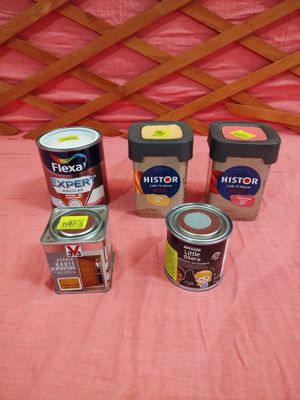 quatre boîtes de conserve sont posées sur un lit recouvert d'une couverture rose