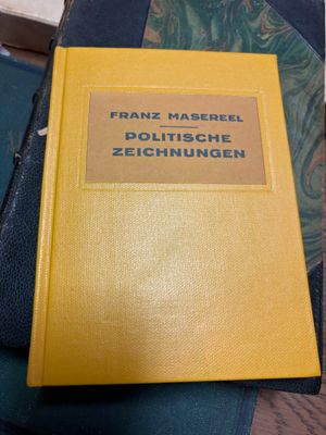 un vieux livre posé sur une table, à côté d'un sac