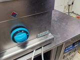 a blue knob on the side of a stainless steel oven