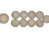six different types of coins are arranged in a row on a white surface