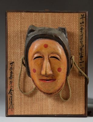 une image représentant un masque en bois accroché à un mur