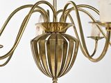 a gold chandelier with a glass shade hanging from it ' s ceiling