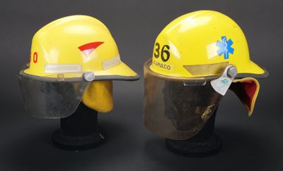 deux casques de chantier jaunes posés l'un sur l'autre sur une surface noire