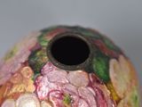 a vase with a flower design on it sitting on a table