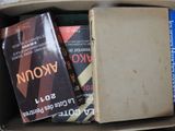 many books in a cardboard box on the floor
