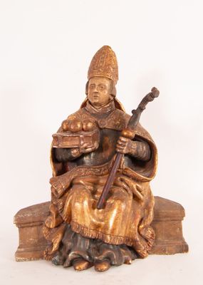 statue d'un homme assis sur une pile de livres, un livre sur les genoux