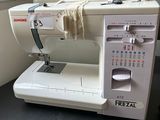 a white sewing machine sitting on a table next to a window