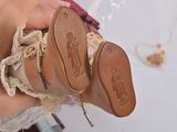 a person holding a pair of shoes with lace on them