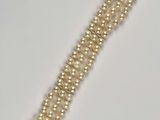 a close up of a bracelet with pearls on it