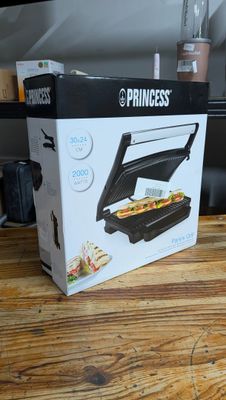 emballage d'un appareil à sandwich posé sur une table en bois devant un mixeur