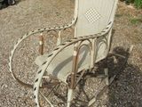 a rocking chair that is sitting in the gravel