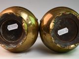 pair of antique brass vases with labels on them sitting on a table