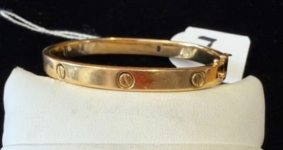 a close up of a gold bracelet on a white cloth