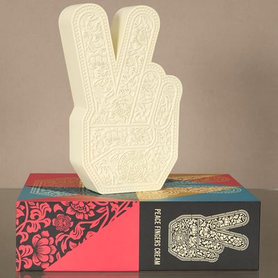 quelqu'un fait le signe de la paix avec la main posée sur un livre