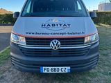une camionnette grise garée sur la pelouse devant un immeuble