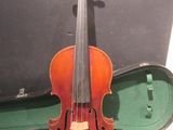 un vieux violon repose dans son étui, posé sur une table