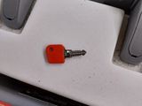 a small red key on the back of a white keyboard