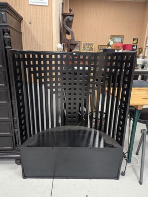 a black chair that is sitting in front of a dresser