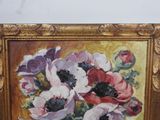 a painting of flowers in a gold frame on the wall
