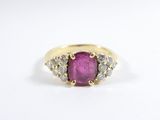a yellow gold ring with a pink stone and white diamonds