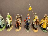 seven figurines of knights riding horses and holding flags