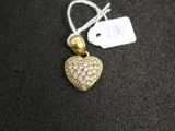 a gold heart shaped pendant with diamonds on a black surface