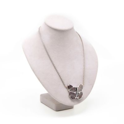 necklace on a mannequin display with a flower in the middle