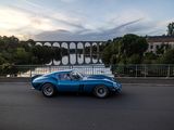 a blue sports car driving down the road near a bridge