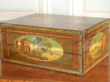 une boîte en bois décorée d'une peinture, posée sur une table