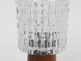 a close up of a glass lamp on a wooden base