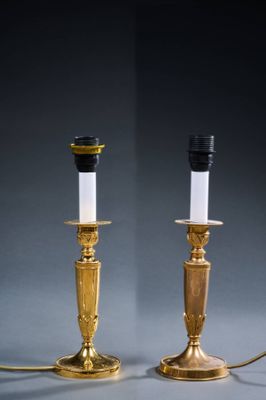 a pair of brass candles with white candlesticks and black candlesticks