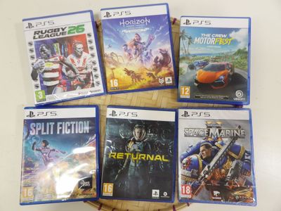 Plusieurs jeux vidéo sont posés sur une table devant un fond blanc.