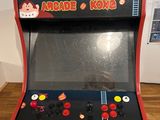 a small arcade machine sitting on top of a wooden table