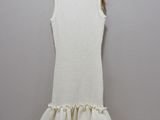 a white dress hanging on a hanger against a wall