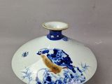 un petit vase bleu et blanc orné d'un oiseau