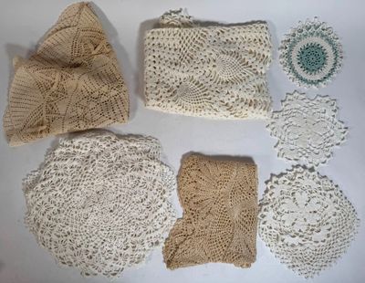 several crocheted doily pieces are laid out on a white surface