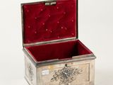 a small silver box with a red velvet lining
