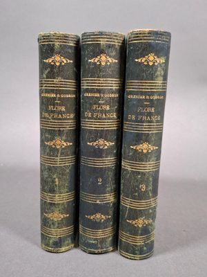 trois vieux livres posés l'un sur l'autre sur une table